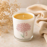 Handmade beeswax candle in luxury glass container with warm neutral styling
